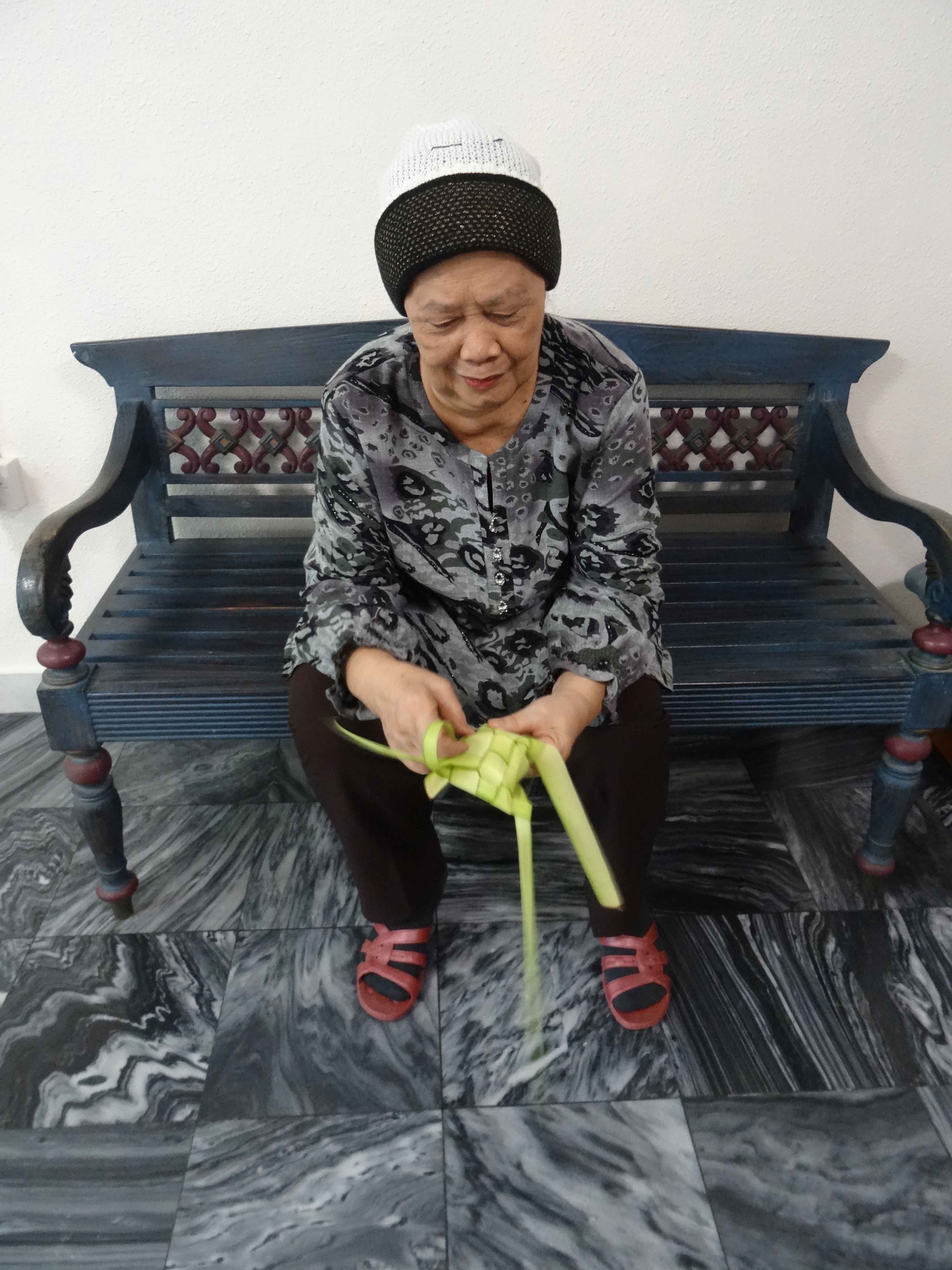 Madam Sabrah weaving <i>ketupat</i>