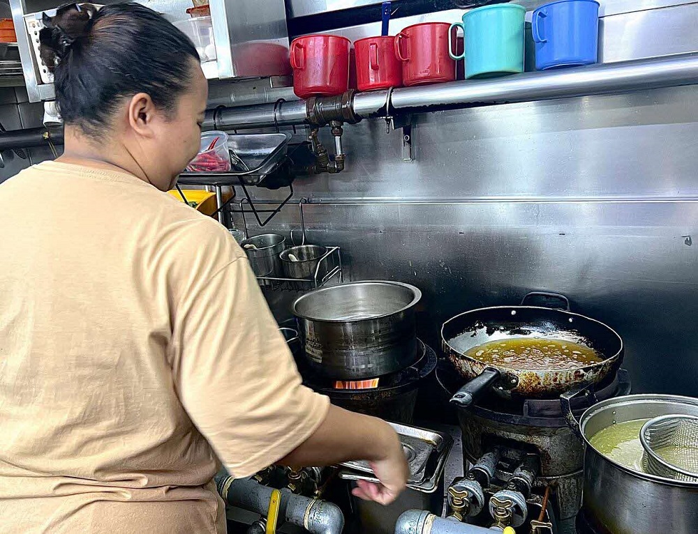 Noraida Jaini is a third-generation hawker, who inherited the stall and its recipes from her grandmother and mother. 2025. Photo courtesy of Afiqah Khalid.