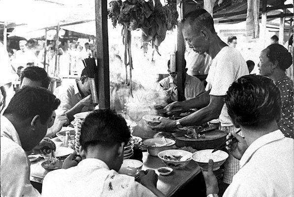 A street side hawker, possibly selling pork innards soup and/or bak kut teh