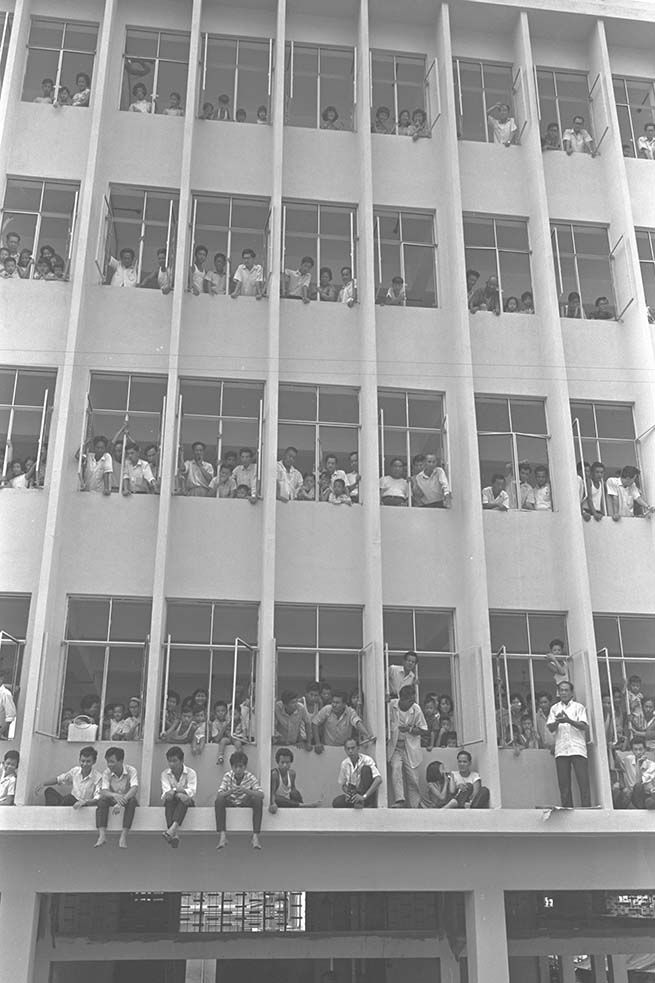 Spectators in 1966 filling up a multi-storey building in Chinatown to view the National Day Parade held at the Padang. (c1966. Image from Ministry of Information and the Arts Collection, courtesy of National Archives of Singapore)