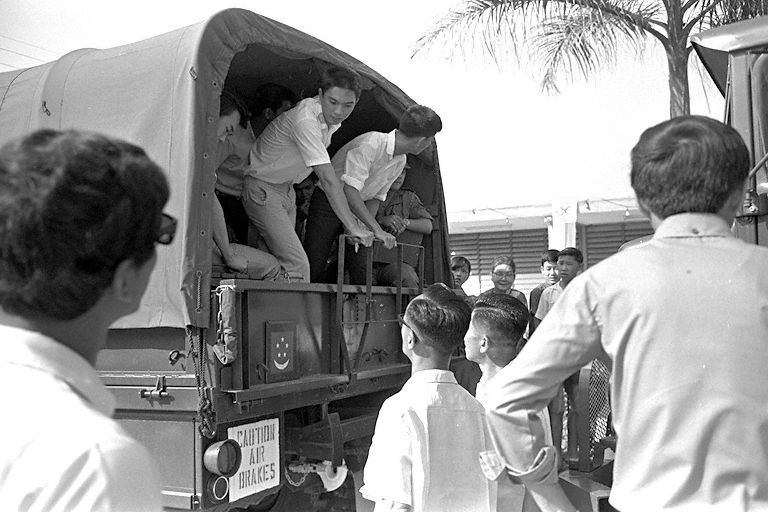 National Service recruits boarding a military truck at Pek Kio Community Centre during their enlistment day