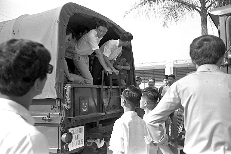 National Service recruits boarding a military truck at Pek Kio Community Centre during their enlistment day.