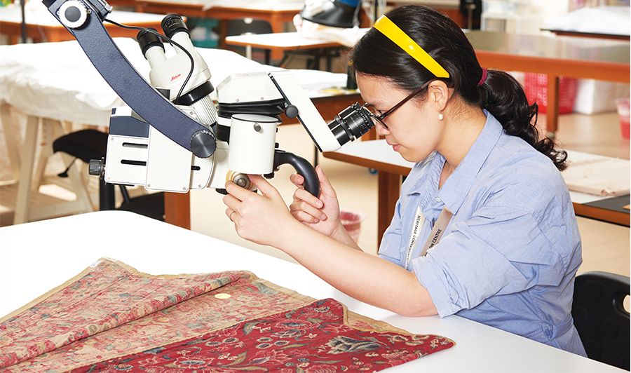 Conservator examining garment