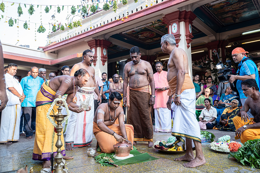 The chief Pandaram (priest) placing the brass pot in which the Karagam will be prepared in.