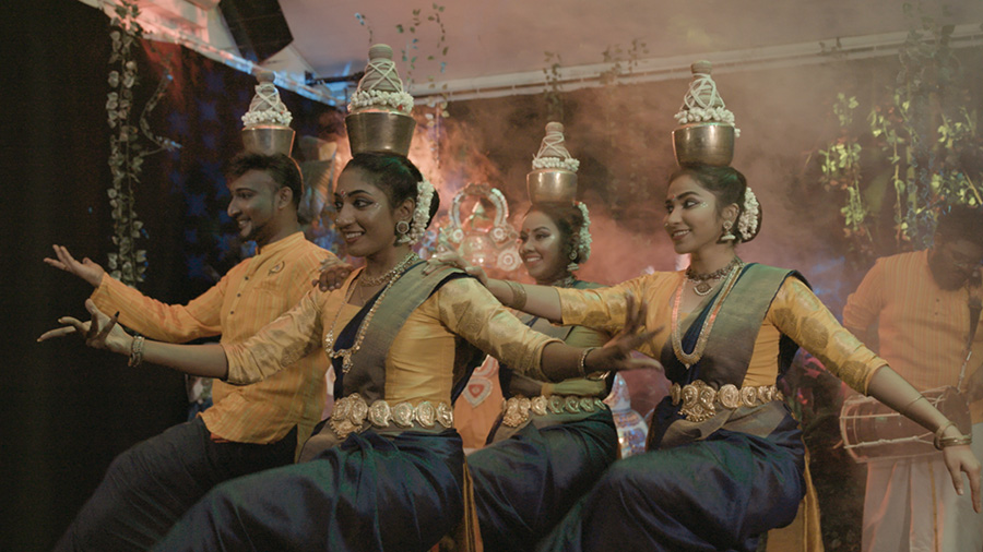 Members of AKT Creations performing the Karagattam dance on stage.