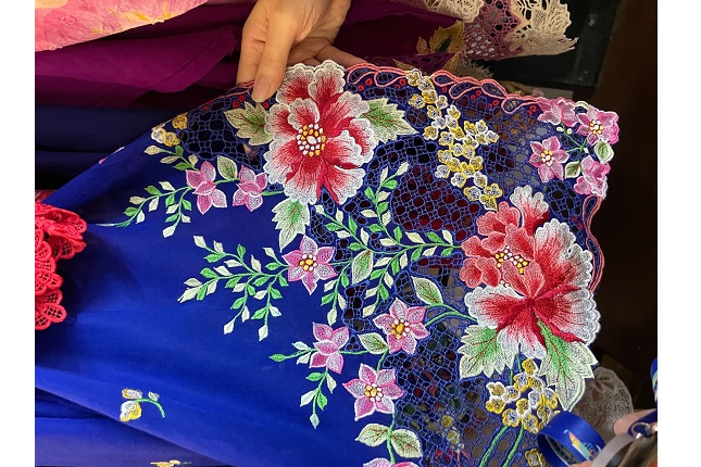 A kebaya featuring traditional floral motifs designed by Mdm Ratianah. 