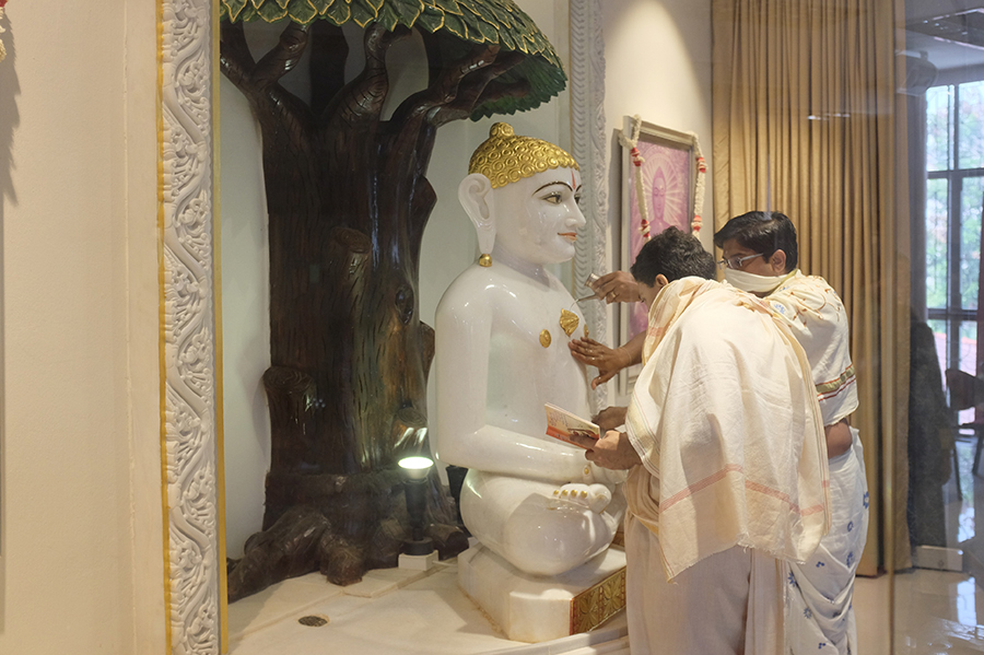 Abisheka (ritual bathing of the divinity to whom worship is offered) performed by male devotees on the idol of Lord Mahavir.