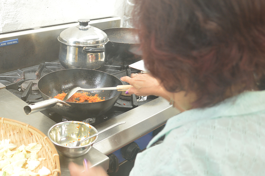 Mdm Ng Swee Hiah frying sambal into a Rempah to be used in other dishes.