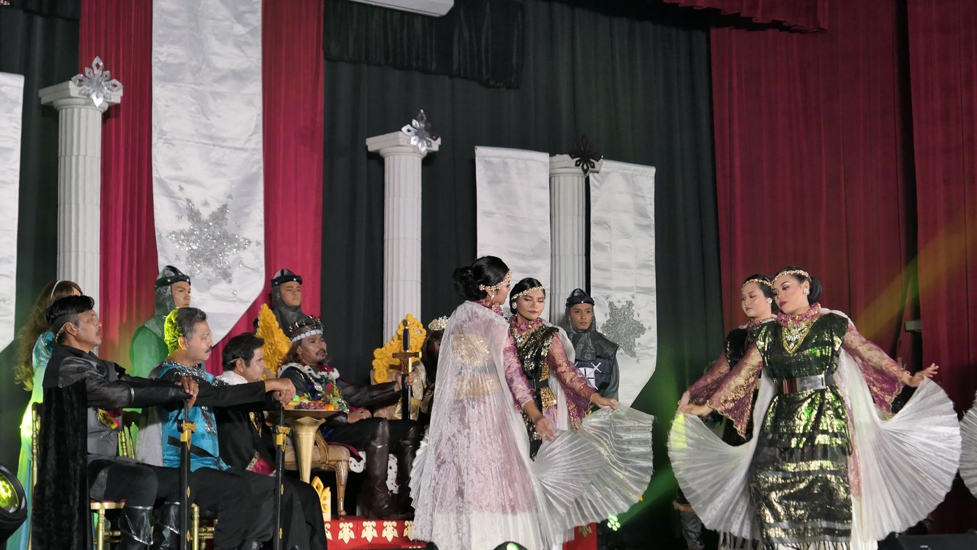 Bangsawan performers playing the role of dancers entertaining a royal court. Music and dance are essential elements of this type of opera and include styles from all over the world. 
