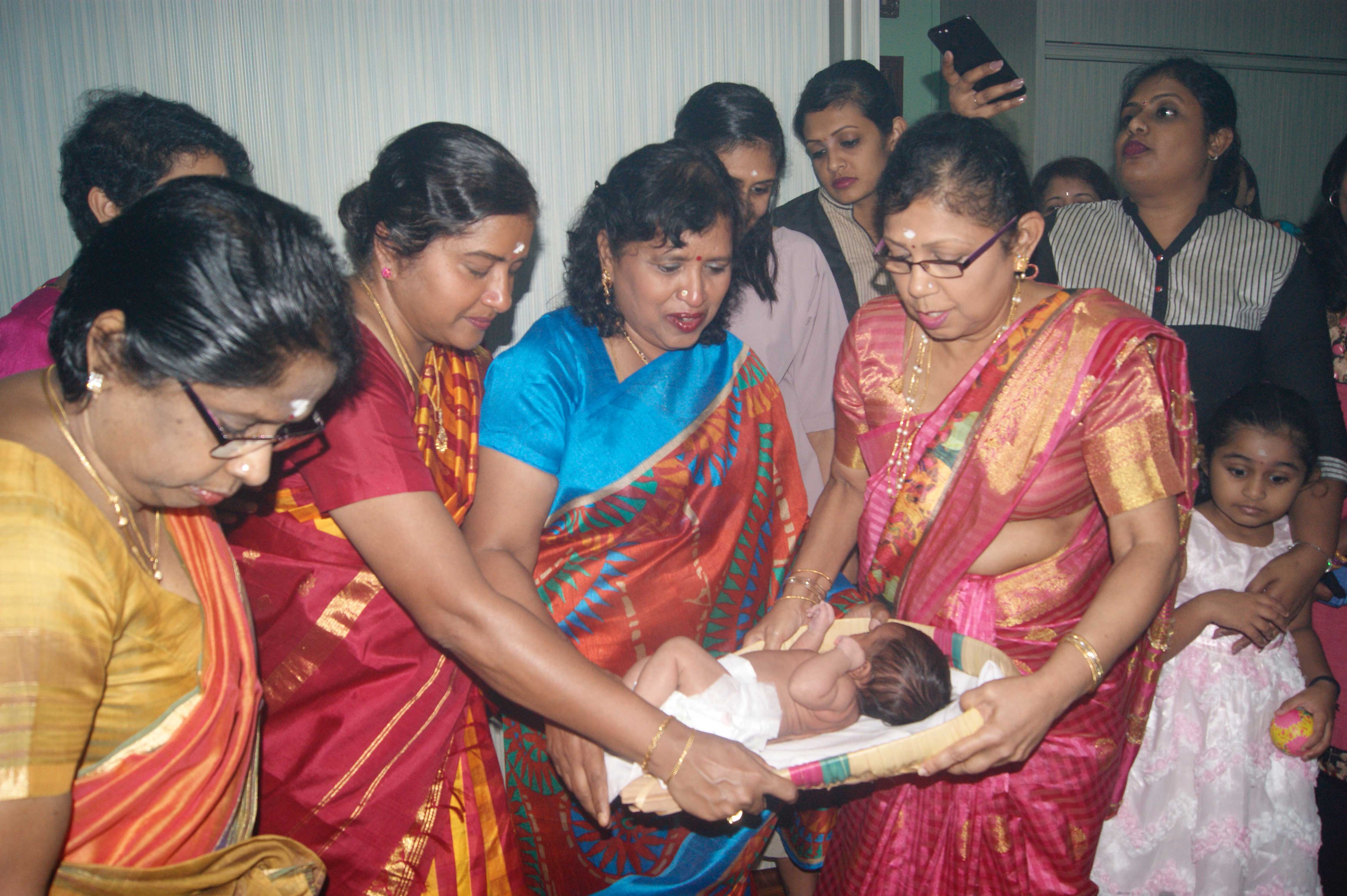 The baby being blessed by her grandmother and grandaunts during the prayer ceremony to Sri Periyachi Amman.