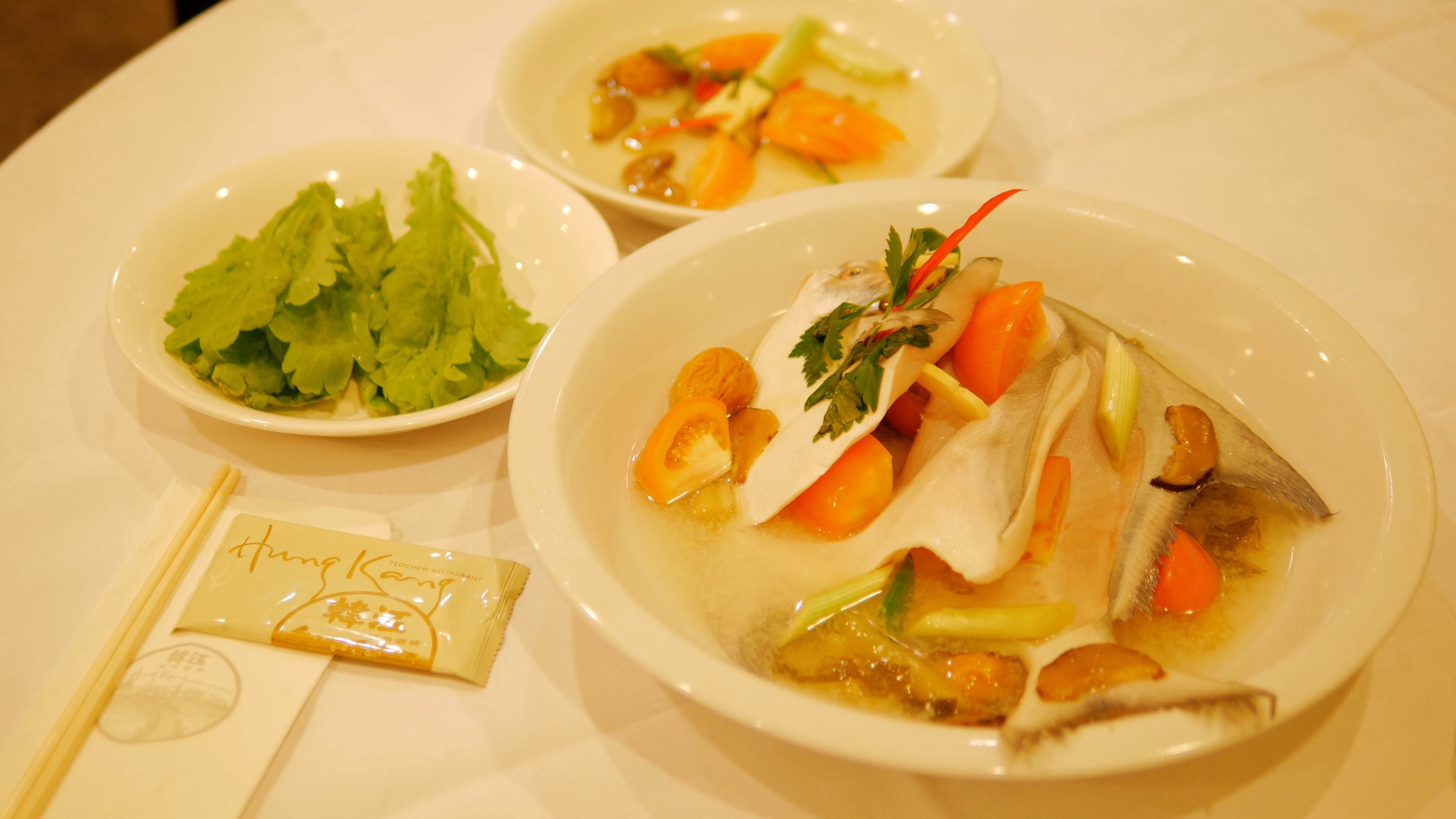 Teochew steamed pomfret with vegetable garnish. 