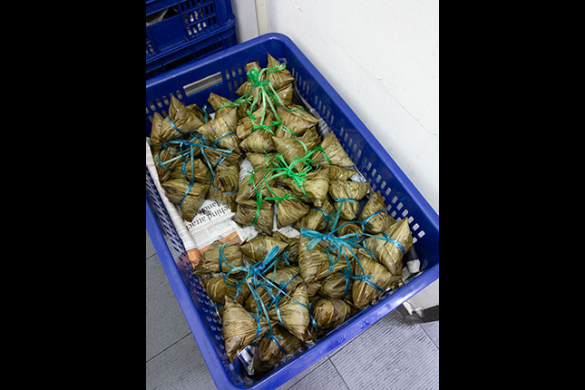 Glutinous rice dumplings are eaten to celebrate Duan Wu Festival. Here, the different types of rice dumplings are indicated by the colour of the string. 