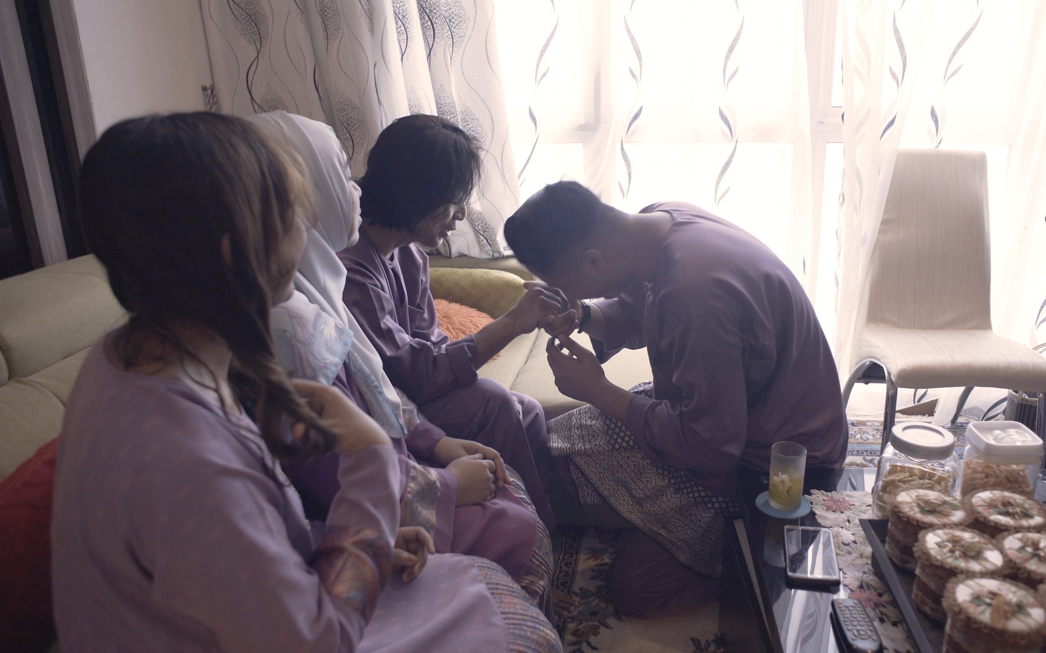 Mr Ismail’s son kissing his father’s hand as he asks for forgiveness for past misdeeds. This is a regional tradition distinct to Muslims in Singapore, Malaysia, Brunei, and Indonesia.