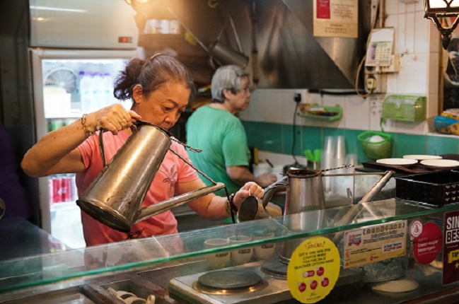 A hawker preparing kopi (local coffee) at Chinatown Complex Food Centre.