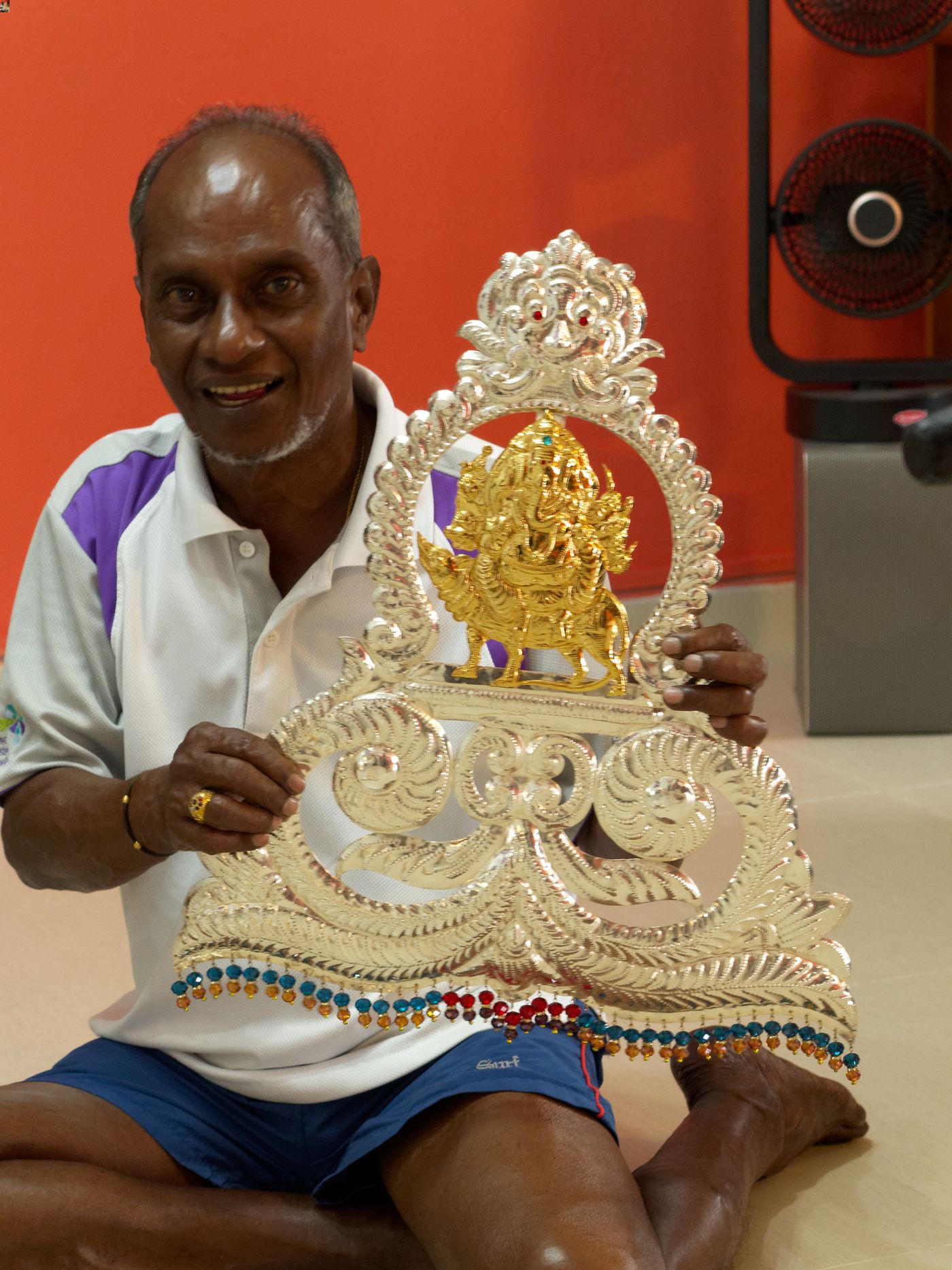 Mr Balakrishnan s/o Sadasivam, who is a kavadi maker, shows a metal decorative element bearing the image of Hindu god Ganesha that is to be attached to a kavadi.