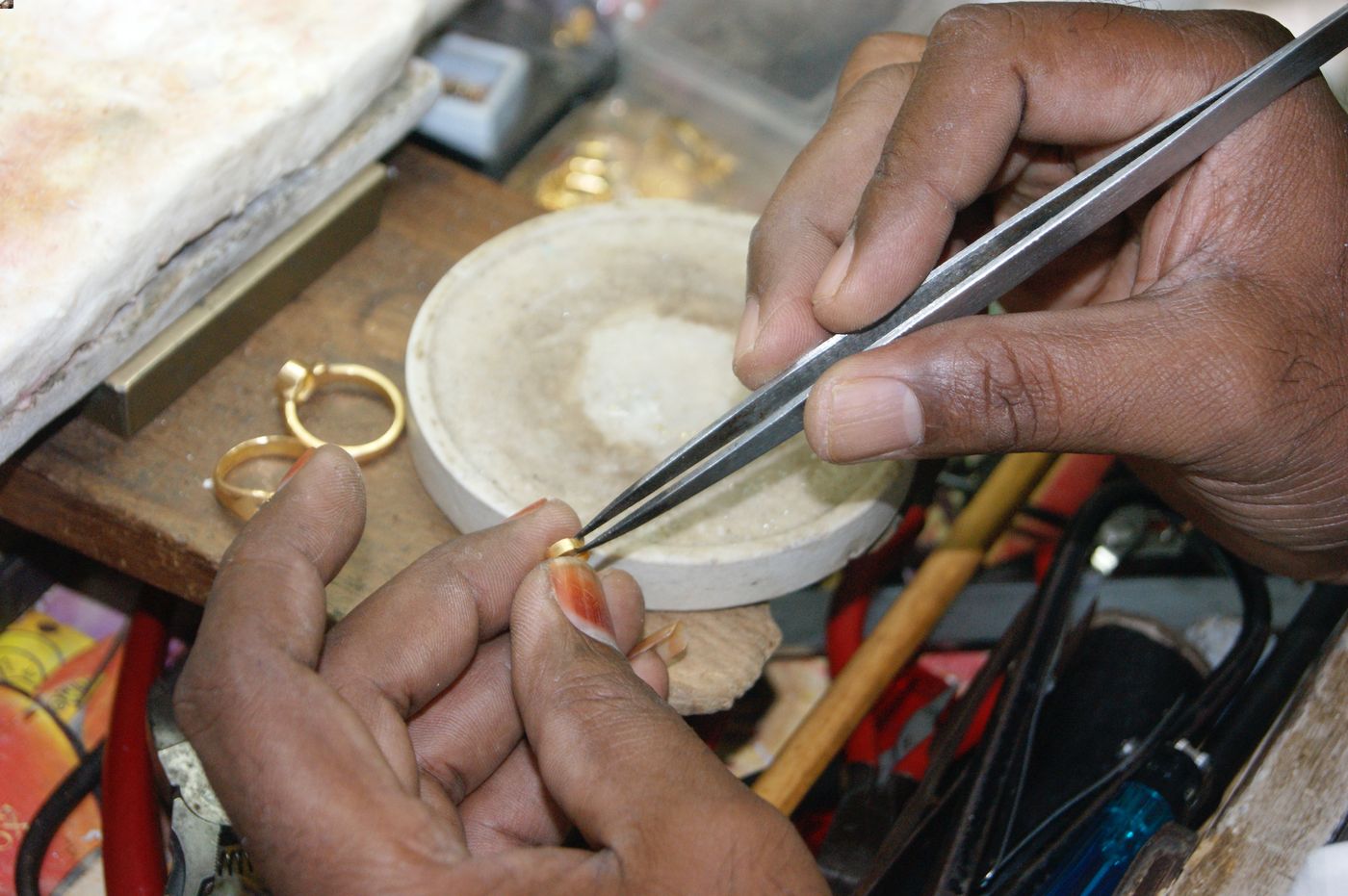 A goldsmith has an individual workstation, and uses tools such as files, hammers, and tweezers to shape and carve gold into jewellery. He usually offers other services as well, such as the repair, alteration, cleaning, and polishing of jewellery.