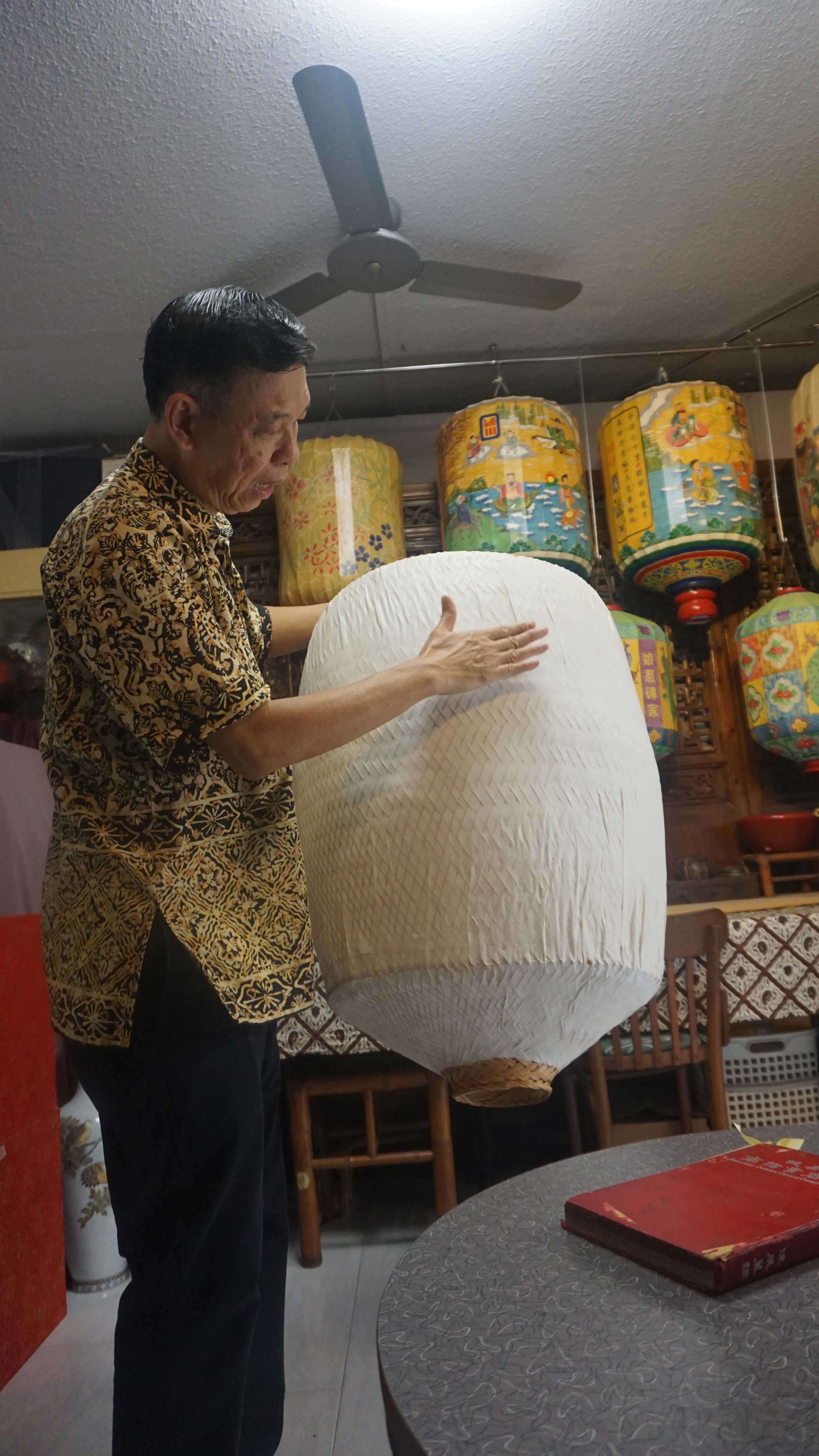 Mr Wong Pui Fatt explains how he lays paper over the lantern frame.