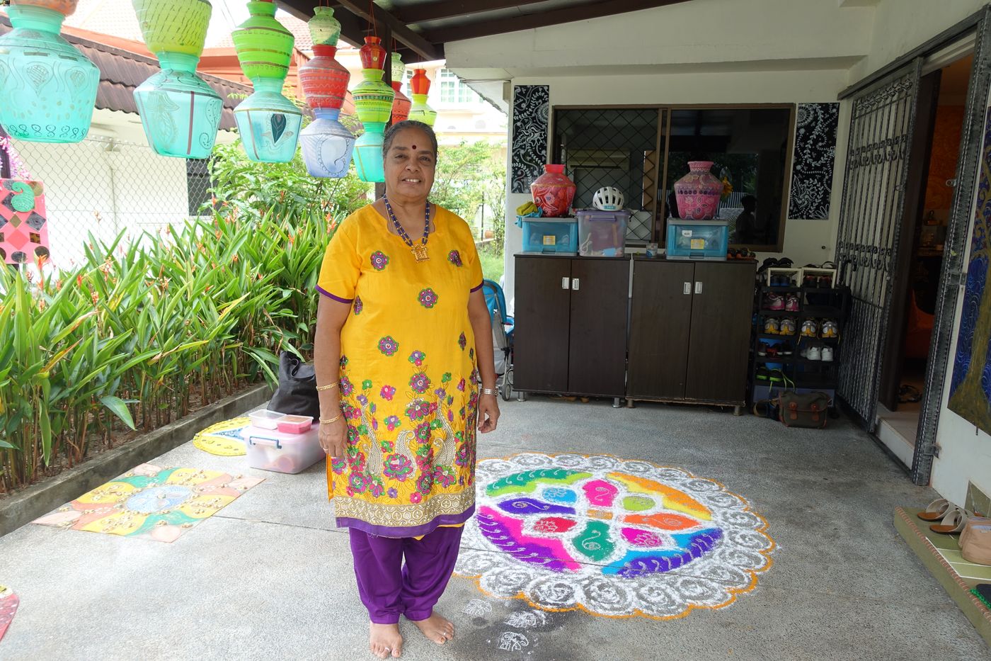 Singapore-based artist Ms Vijayalakshmi Mohan with a colourful rangoli she created. These floor decorations are often drawn outside one’s home to bring good luck.