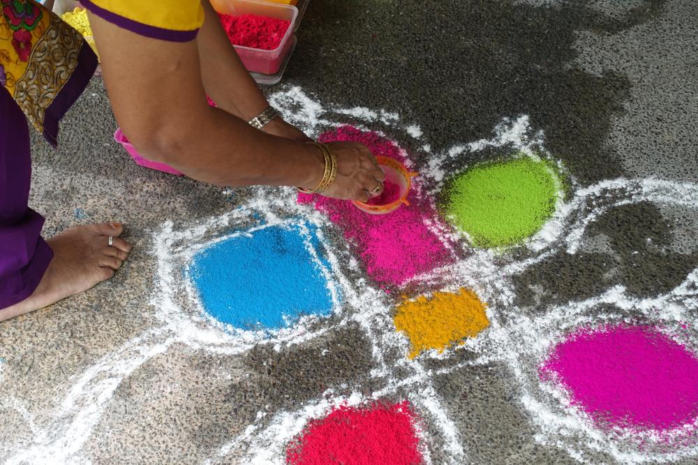 Ms Vijayalakshmi Mohan first outlined her rangoli pattern in white, before filling up the inner spaces with coloured powders.