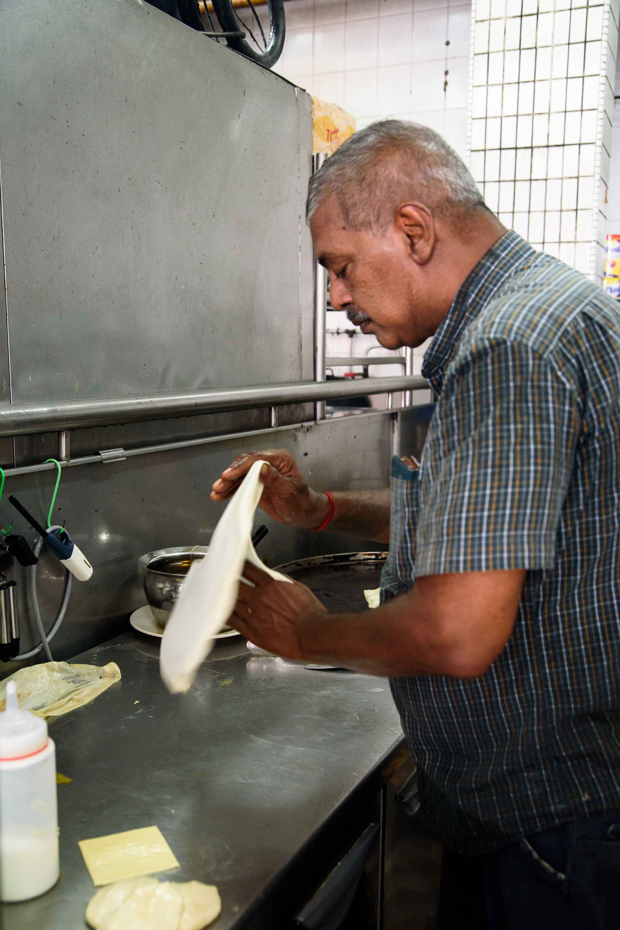 Mr Mohgan flipping prata dough.