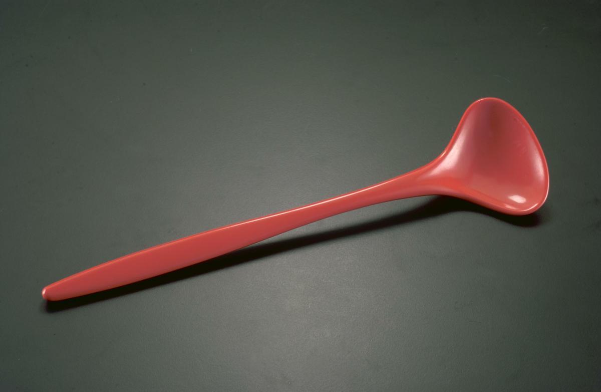 Orange plastic spoon-shaped salad tosser from a picnic set