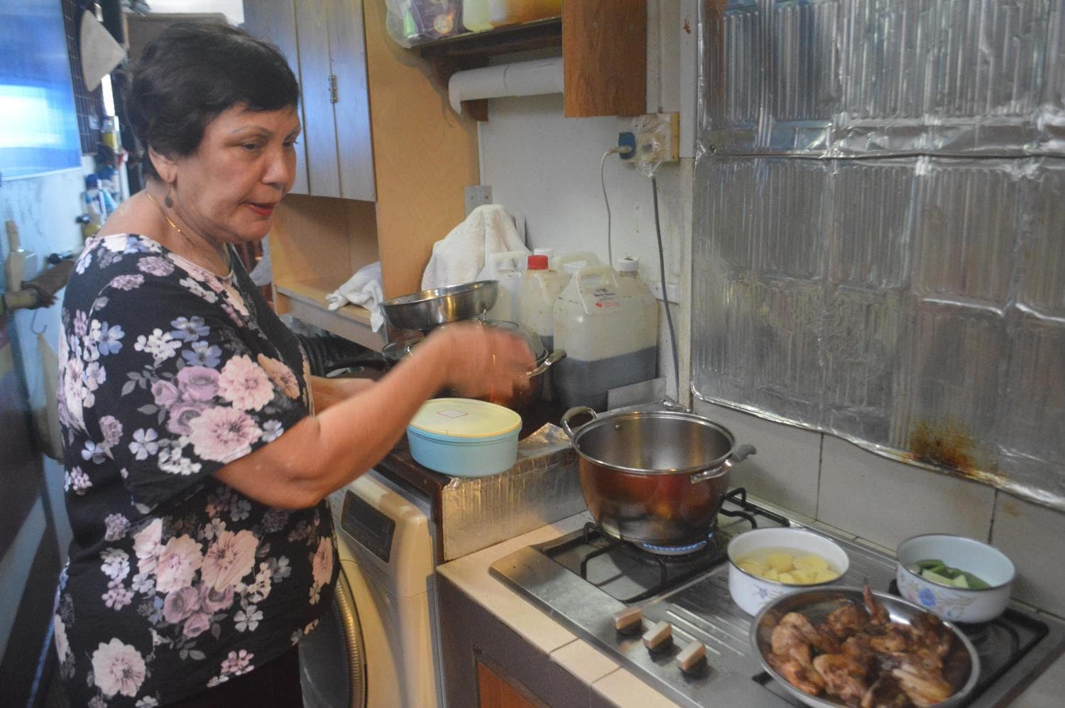 Madam Mary Gomes demonstrating how to fry rempah, a herb and spice paste that is a key ingredient in curries.