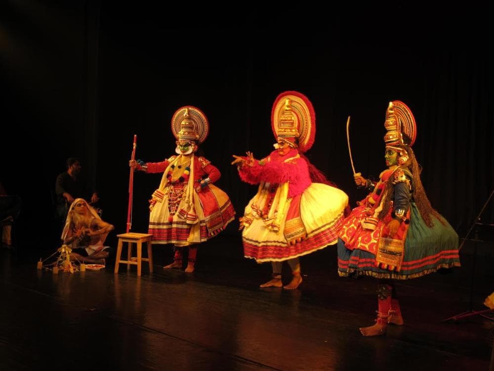 Kathakali performers on stage. Their distinctive costumes and make-up showcase different character types and are important elements of the art form.