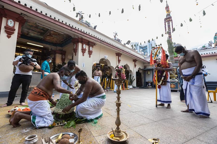Practitioners tying the Karagam with strings of jasmine flowers. Credits: Hindu Endowments Board.