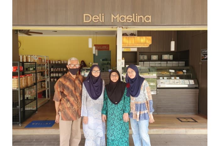 <p style="border: none;"><a href="/assets/3ec5fcbc-9cf3-415b-bcca-2774336692fb/Fauziah and Maskiah outside Deli Maslina.jpg">Sisters Fauziah and Maskiah binte Haji Ahmad Shariff (centre) with Maskiah&rsquo;s husband Ahmad Don and daughter Adibah photographed outside their store, Deli Maslina which specialises in traditional Malay desserts</a>