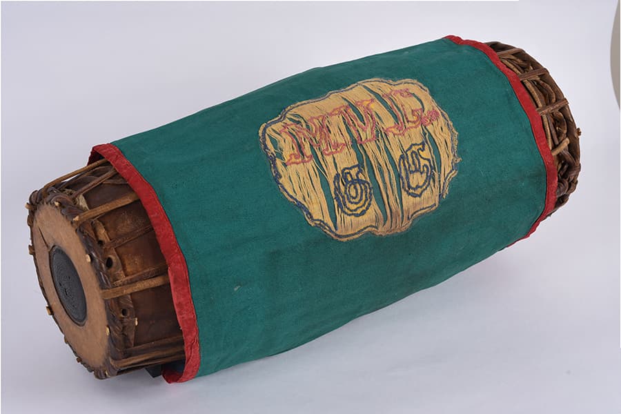 <a href="/assets/6fea8dc9-98d1-48c8-a466-b0ea8b050ec5/9-dsc9624n.jpg"><strong>A mridangam (&ldquo;drum&rdquo; in Tamil) from the collection of MV Gurusamy</strong></a><br>
1940s/1950s, Singapore<br>
Wood, Cloth Cover<br>
<em>Gift of Ms Sashikala Samugan Nathan and Mrs Chandrakala Kunaseelan, Collection of Indian Heritage Centre</em>