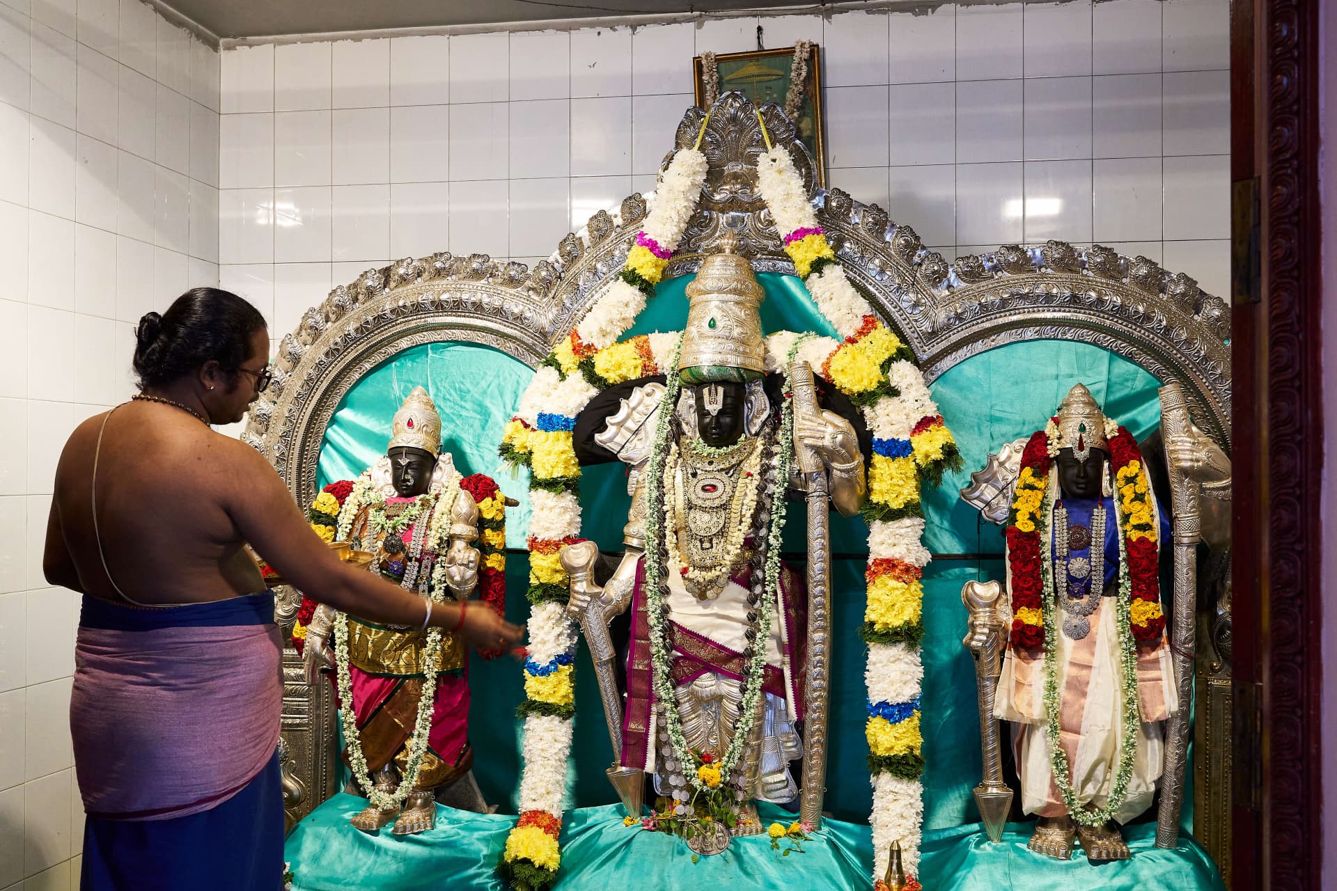 Priest performing a ritual at the Sree Ramar sanctum.
