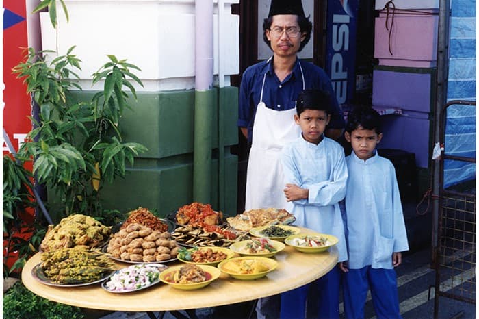 这张照片摄于1990年代，左起为餐馆联合创始人莫哈默辛（Mohamad Zin bin Harun）及其儿子阿里夫（Mohamad Ariff bin Mohamad Zin）和纳兹里（Muhamad Nazri bin Mohamad Zin）。