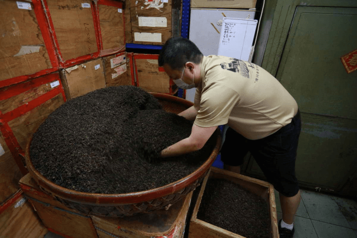 Blending tea leaves by hand in a large bamboo basket at Pek Sin Choon.