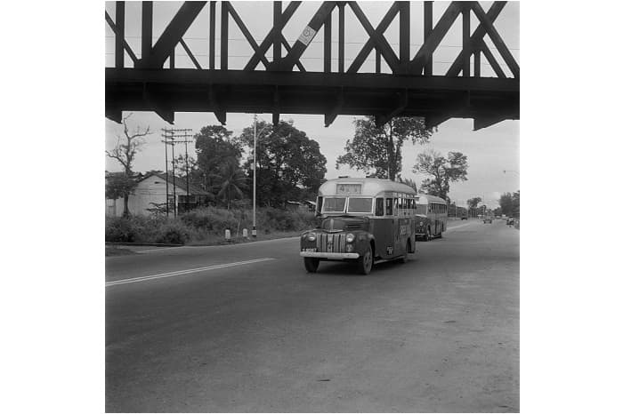 <strong>Green Bus Company Ford at Bukit Timah Railway Station, Passing Under Bridge</strong><br>
June 1955<br>
F. W. York Collection<br>
Courtesy of National Archives of Singapore