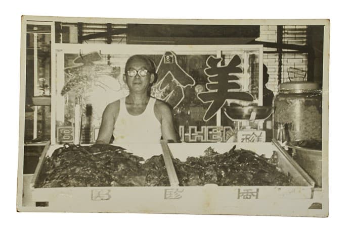<span>Gambar Teo Swee Ee, pengasas Bee Cheng Hiang, diambil sekitar tahun 1950-an-1960-an di depan papan tanda kedai yang beliau reka bentuk sendiri.</span>