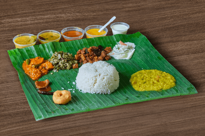 இந்தப் புகைப்படத்தில் வழக்கமான தென்னிந்திய சைவச் சாப்பாட்டைக் காணலாம். காய்கறி பிரட்டல், அவியல், பருப்புக் கறி, ஊறுகாய், இனிப்புப் பலகாரம் உள்ளிட்ட பலவகை பதார்த்தங்களும் இந்தச் சாப்பாட்டில் உள்ளடங்கும்.