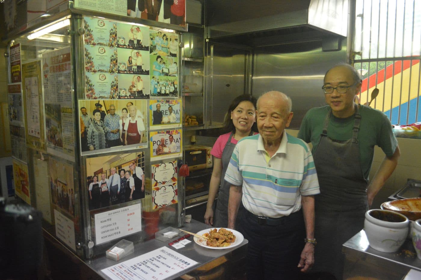 Mr Cheng Kong Sang (centre), with a plate of Chinese rojak at his stall, Toa Payoh Rojak. Behind him are his daughter, Ms Regina Cheng, and her husband, Mr Lim Swee Seng.