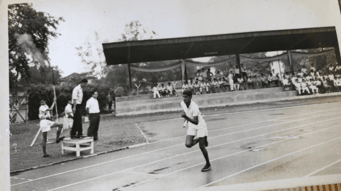 Joseph John competing in a 4x100m relay event at the Beatty School Sport&rsquo;s Day held at Farrer Park Stadium in c.1966/67.
