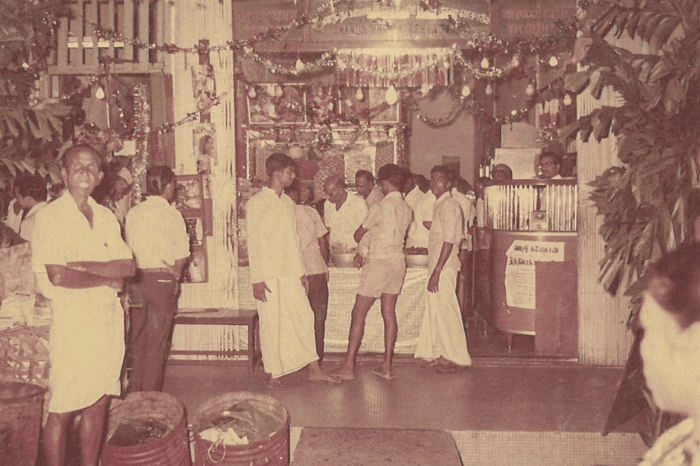 1970களில் எடுக்கப்பட்ட இந்தப் புகைப்படத்தில், எலிசன் கட்டடத்தில் முன்பு அமைந்திருந்த ஆனந்த பவன் உணவகத்தைக் காணலாம். வலது பக்கத்தில் உள்ள கல்லாப்பெட்டிக்குப் பின்னால் இரண்டாம் தலைமுறை உரிமையாளர்களான K. நடராஜன் (இடமிருந்து மூன்றாமவர்), M.K. ராமச்சந்திரா ஆகியோரைக் காணலாம்.