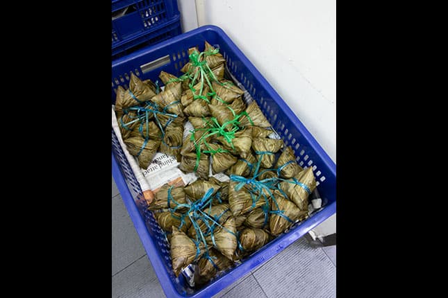 Glutinous rice dumplings are eaten to celebrate Duan Wu Festival. Here, the different types of rice dumplings are indicated by the colour of the string.