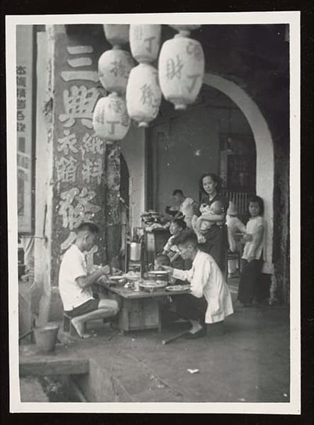 <strong>Photograph of a family eating at a hawker stall</strong><strong><br>
</strong>1938&ndash;1939<br>
2007-50928-276