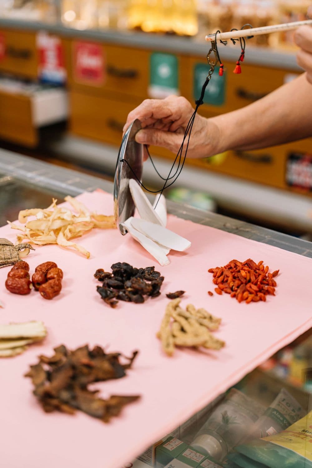 Chin Siong preparing medicinal herbs, slicing off the roots, for use in traditional Chinese remedies.