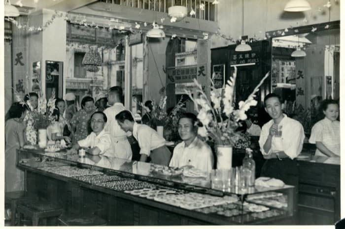 <span>Gambar ini, yang diambil sekitar tahun 1950-an-1960-an, menunjukkan ramai pembeli di Tin Sing, salah satu kedai emas dan barang kemas paling popular di sepanjang South Bridge Road.</span>