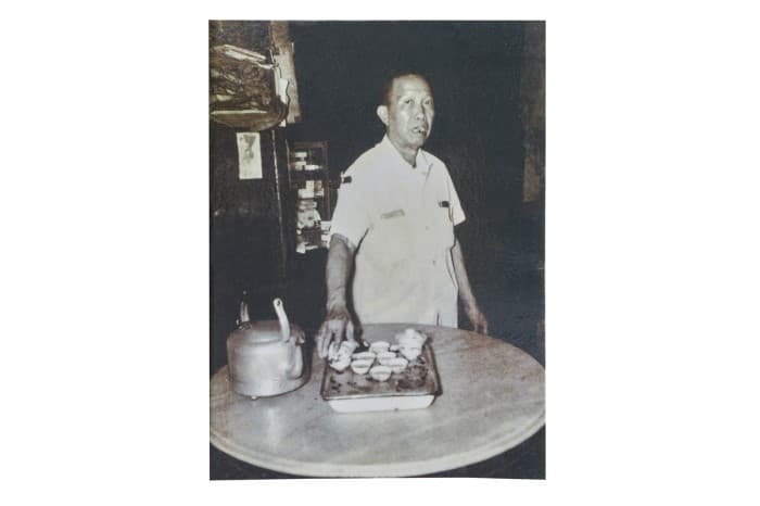 <span>Ini ialah gambar pengasas Pek Kim Aw, diambil pada tahun 1960-an, dengan set teh yang digunakan untuk merasa minum teh.</span>