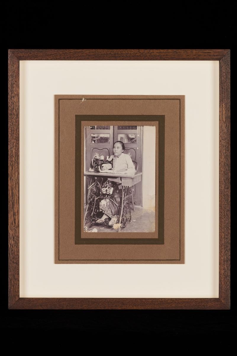Photograph of Mrs Tan Gwat Bing at a sewing machine