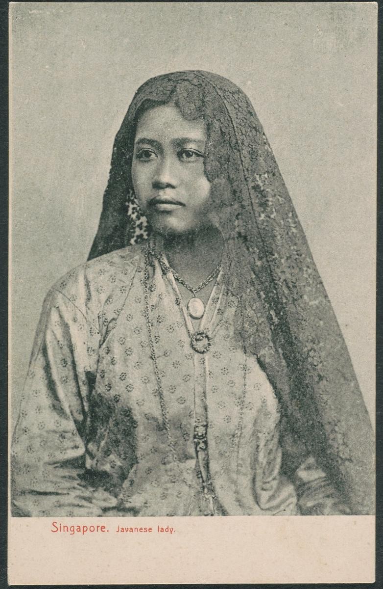 A Malay woman in a ‘baju panjang’ with a ‘selendang’ over her head