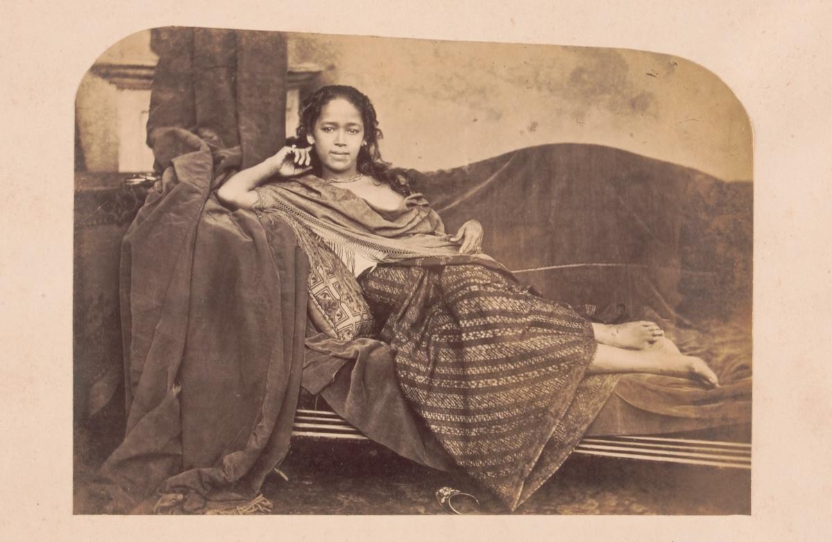 Young woman of mixed race ('nonna') reclining on a couch
