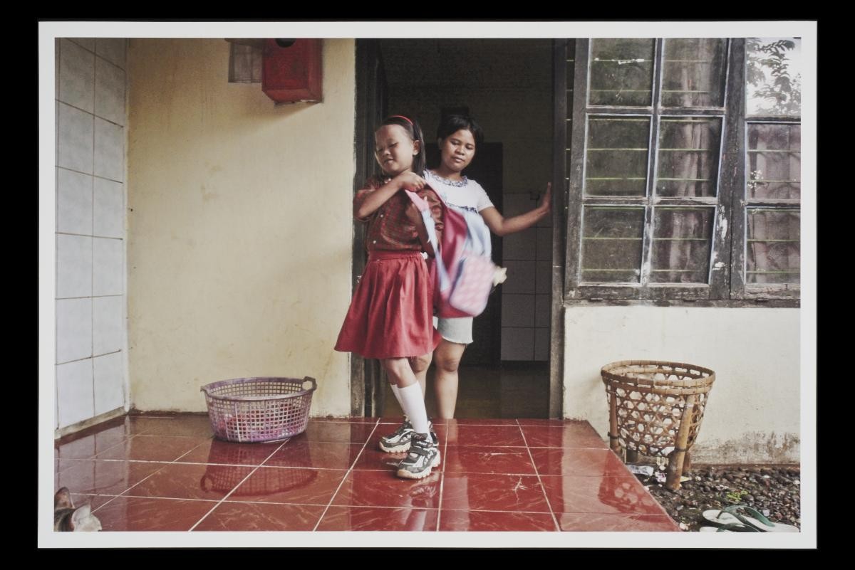 Photograph of Indonesian domestic helper Sugiyani Waryomiharjo with her daughter, Rola, at home in her village in Indonesia