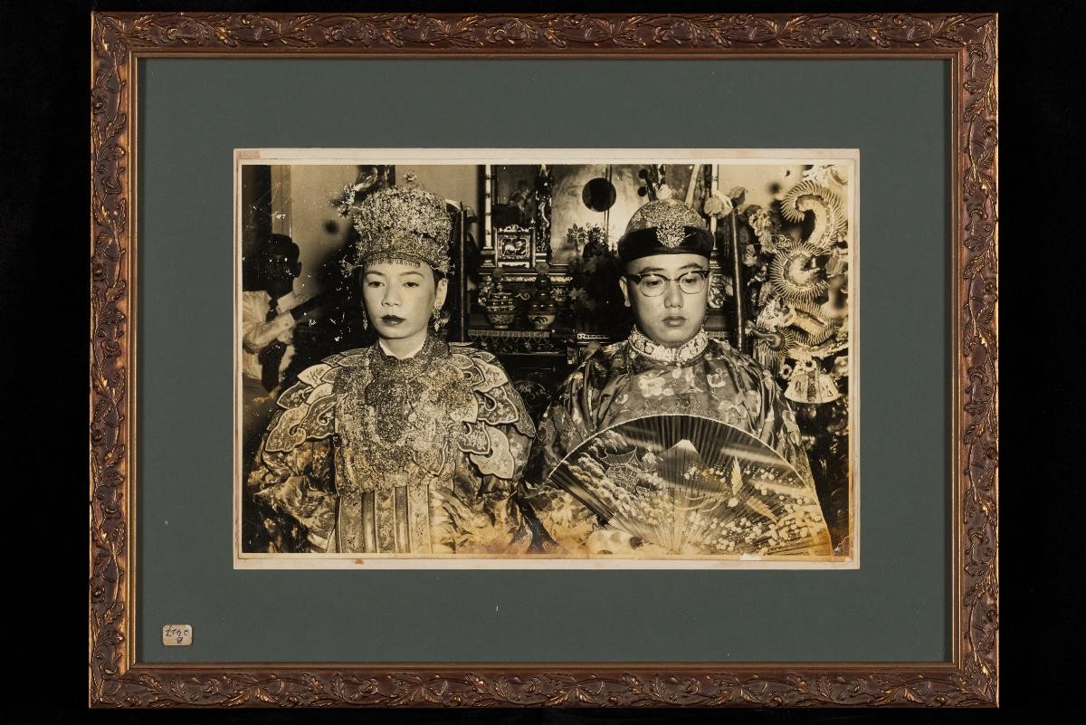 Photograph of a Peranakan bride and groom with altar behind