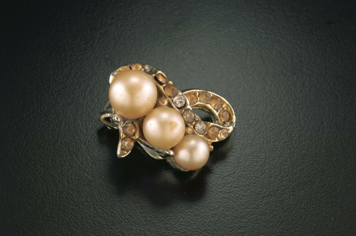 A pair of clip-on ear rings with red beads and pearls that belonged to a notable women's rights activist